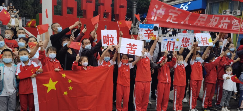 9月13日，瀘定縣，當地居民舉著條幅送別救援隊伍。程雪力攝