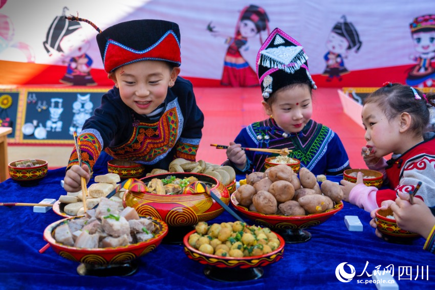 彝族年被稱為“嘴巴的節(jié)日”，圖為幼兒園內(nèi)的小朋友們?cè)谄穱L彝族傳統(tǒng)美食。范艷民攝