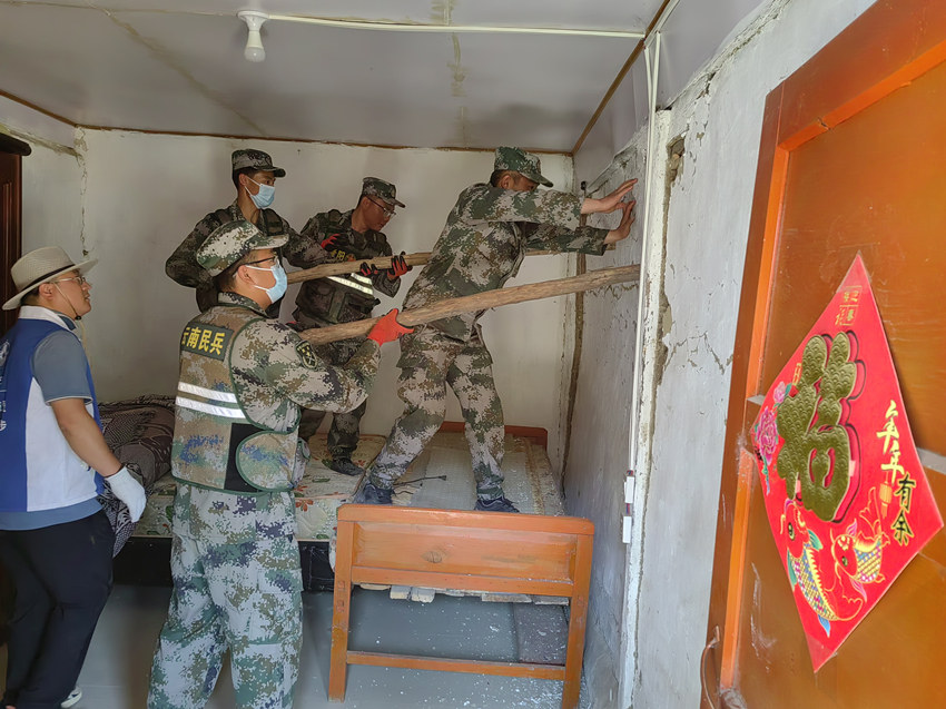 楊?lèi)?ài)理（右一）在排除房屋安全隱患。陸軍第77集團(tuán)軍某旅供圖