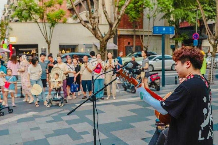 街頭藝人的表演深深吸引路人。成都市武侯區(qū)玉林街辦供圖