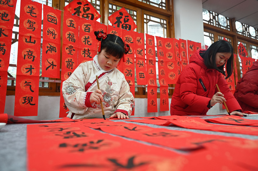 為社區(qū)居民書(shū)寫(xiě)春聯(lián)和“福”字。蘭自濤攝