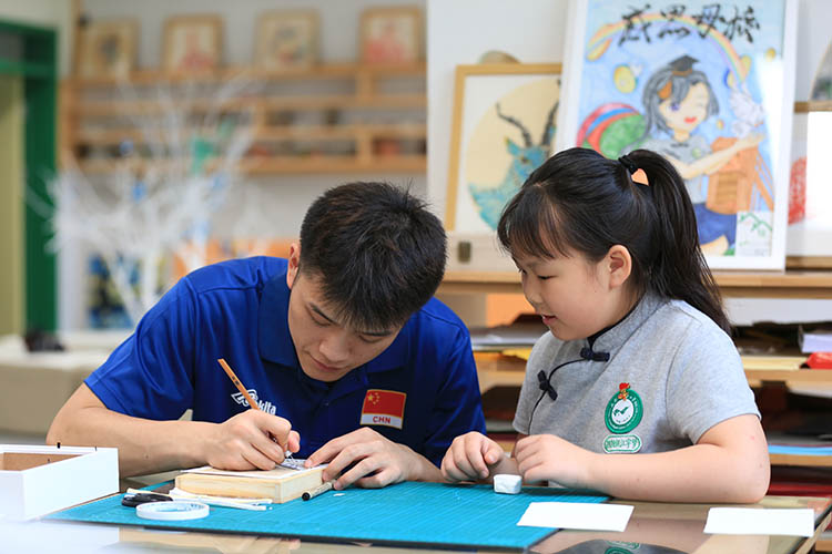 老師輔導學生剪紙。成都市草堂小學西區分校供圖