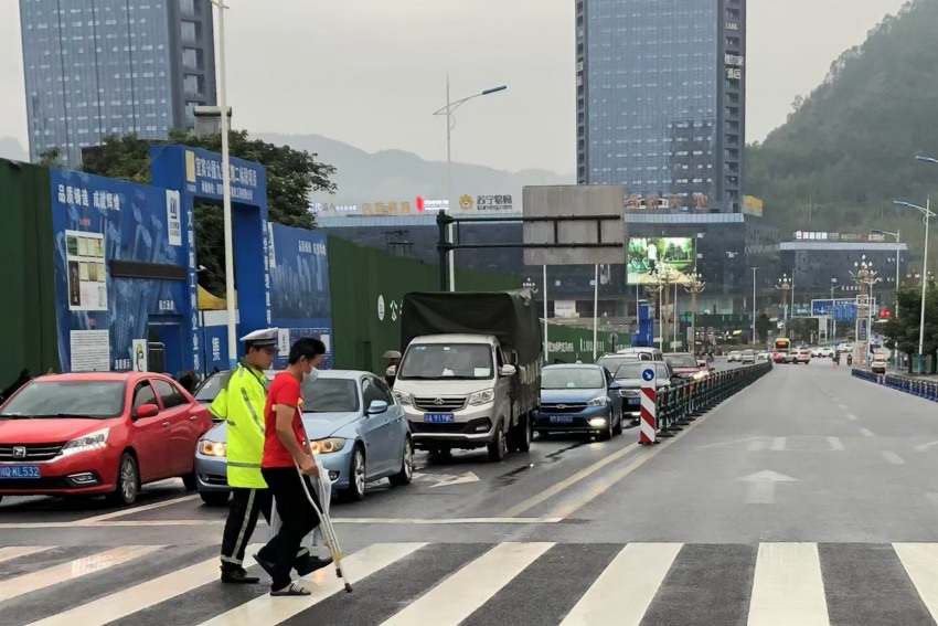 羅文攙扶行動不便的病人過馬路。四川公安供圖